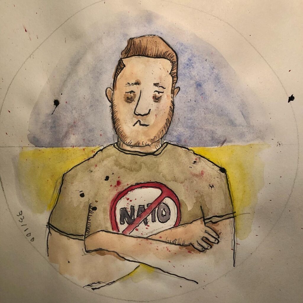 caricature of Volodomir Zelenski wearing a Tshirt with a "no NATO" symbol on its front.